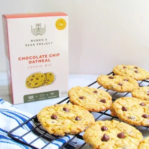 Women's Bean Project chocolate chip oatmeal cookie mix next to a sheet of freshly prepared cookies