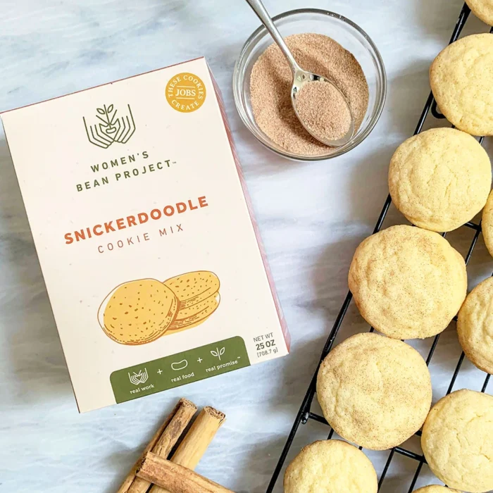 Women's Bean Project Snickerdoodle cookie mix next to a rack of freshly baked snickerdoodle cookies