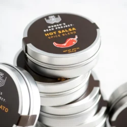 A stack of Women's Bean Project Hot Salsa Spice Blend tins.